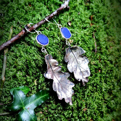 Silver leaf earrings with blue sea glass on a mossy background