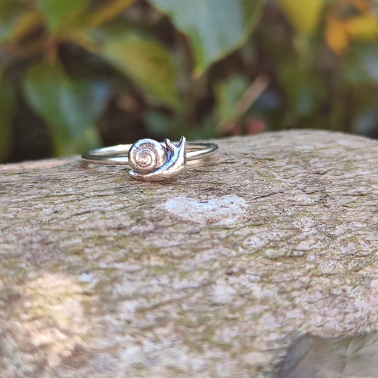  100% recycled silver stacking ring with a small, 3D Snail sitting on a log in front of ivy