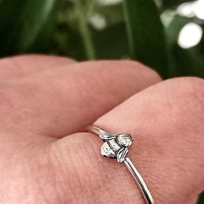 Silver stacking bee ring on a person's finger